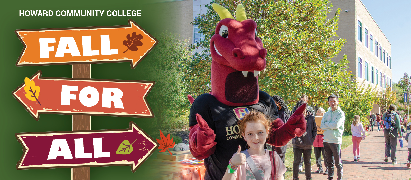 Howard Community College Duncan mascot and a child pose beside colorful Fall for All signs on campus with autumn leaves and trees in the background.