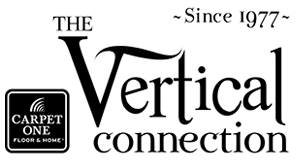 Logo for The Vertical Connection Carpet One Floor & Home. The text reads “The Vertical Connection” with stylized typography and “Since 1977” above. A square logo on the left includes “Carpet One Floor & Home” with a fan-like graphic above the text.