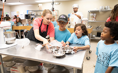 A Kids on Campus adjunct instructor teaching a baking class.